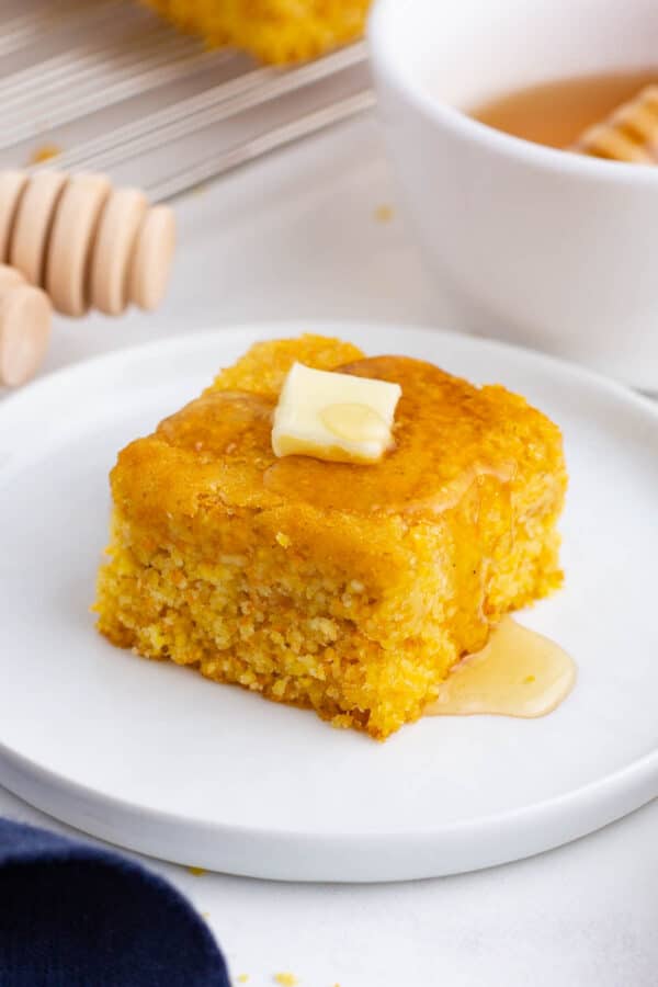 Cornbread is served with a bit of butter.