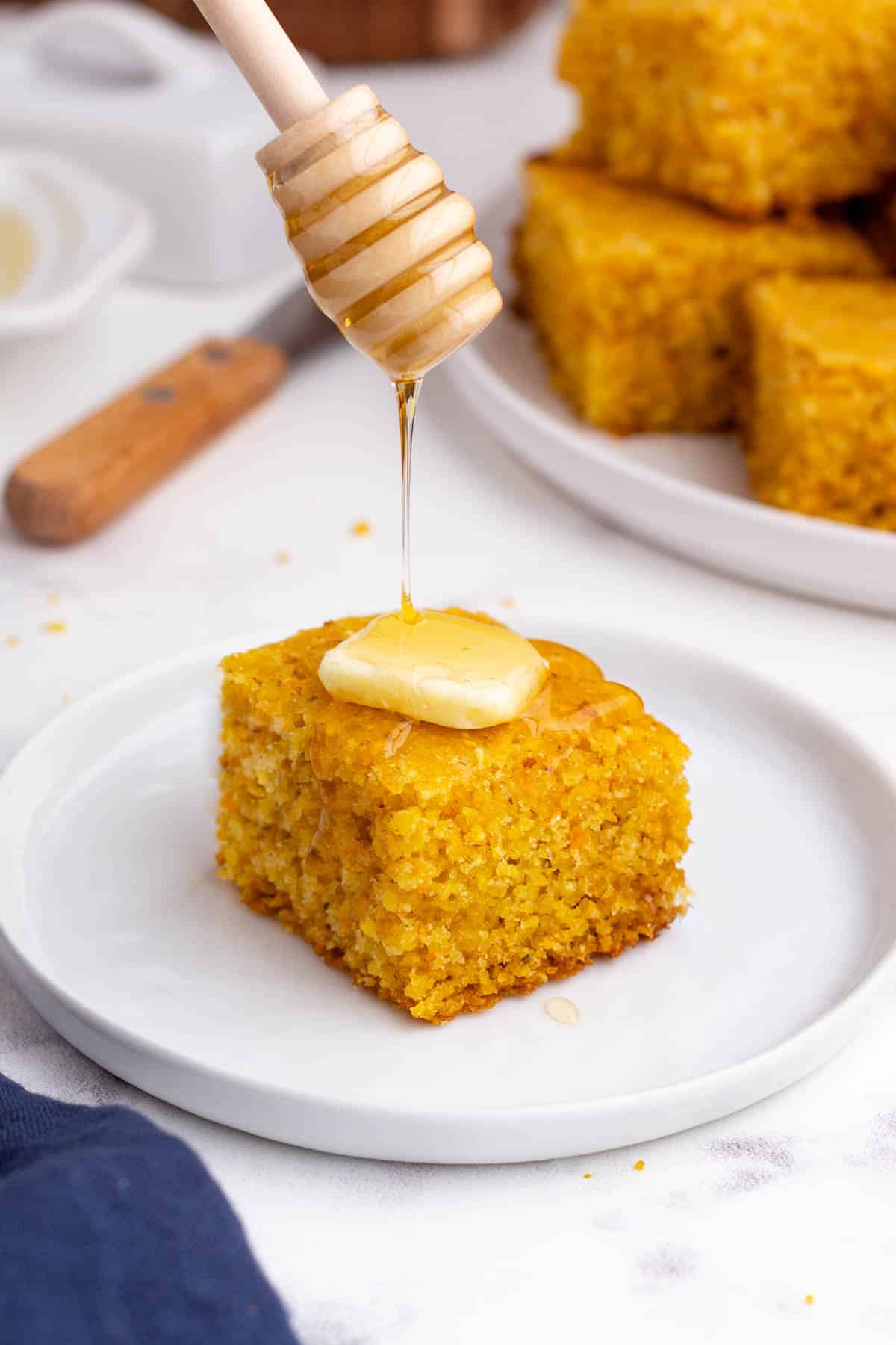 Honey is drizzled over a slice of cornbread.