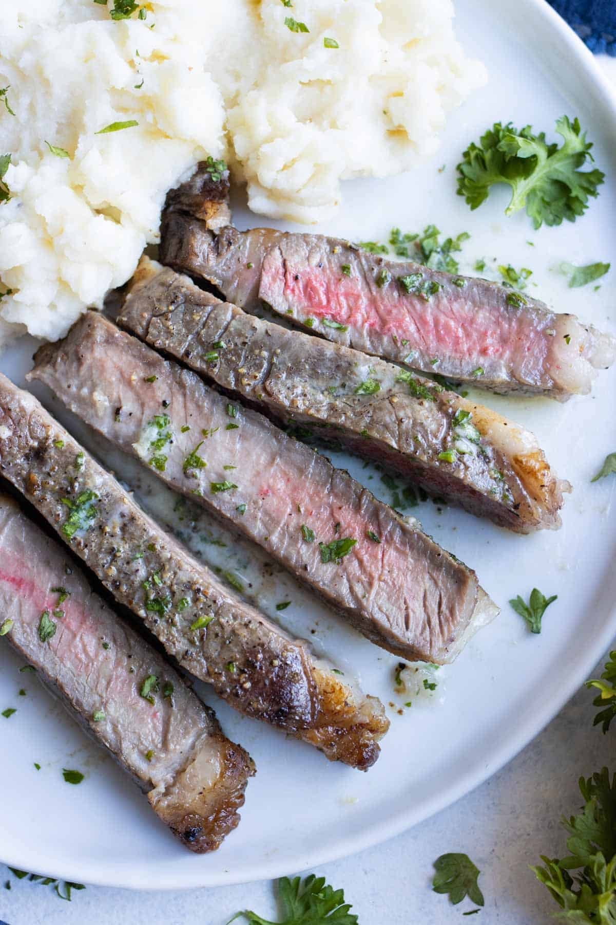 Medium-rare steak is cooked in the air fryer and served with mashed potatoes.