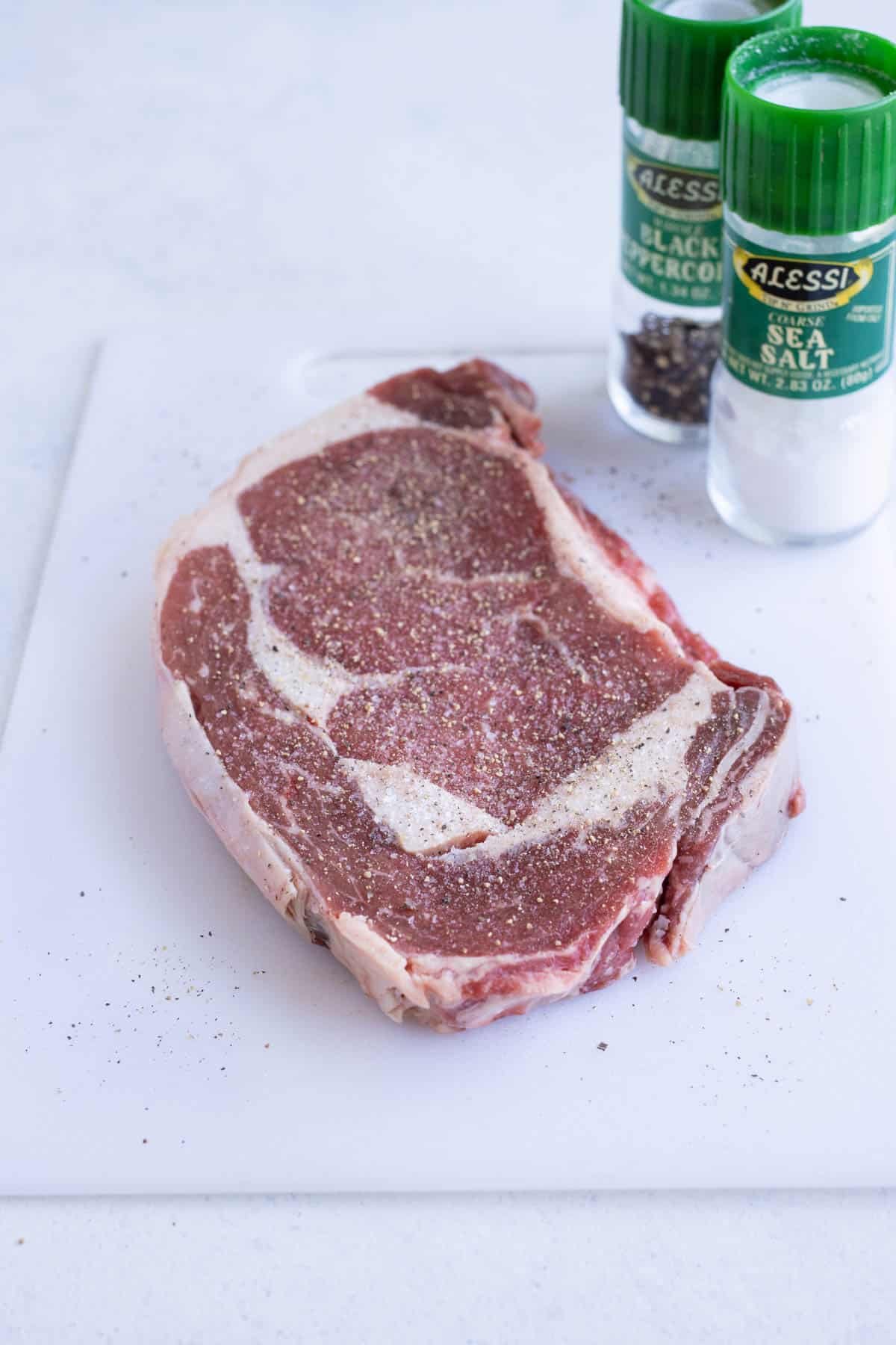 Steak is seasoned with salt and pepper.