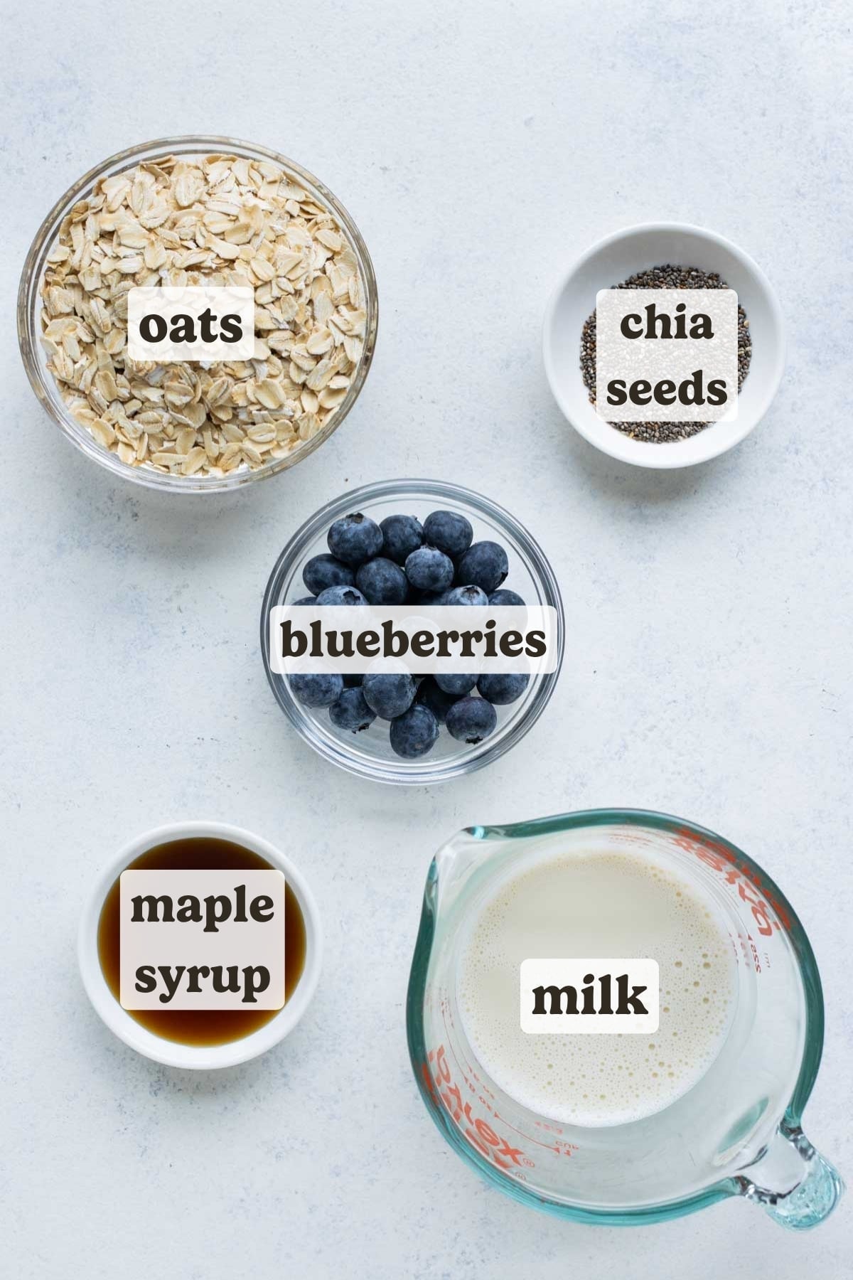 Rolled oats, blueberries, chia seeds, milk, and maple syrup are the ingredients for this overnight oats recipe.