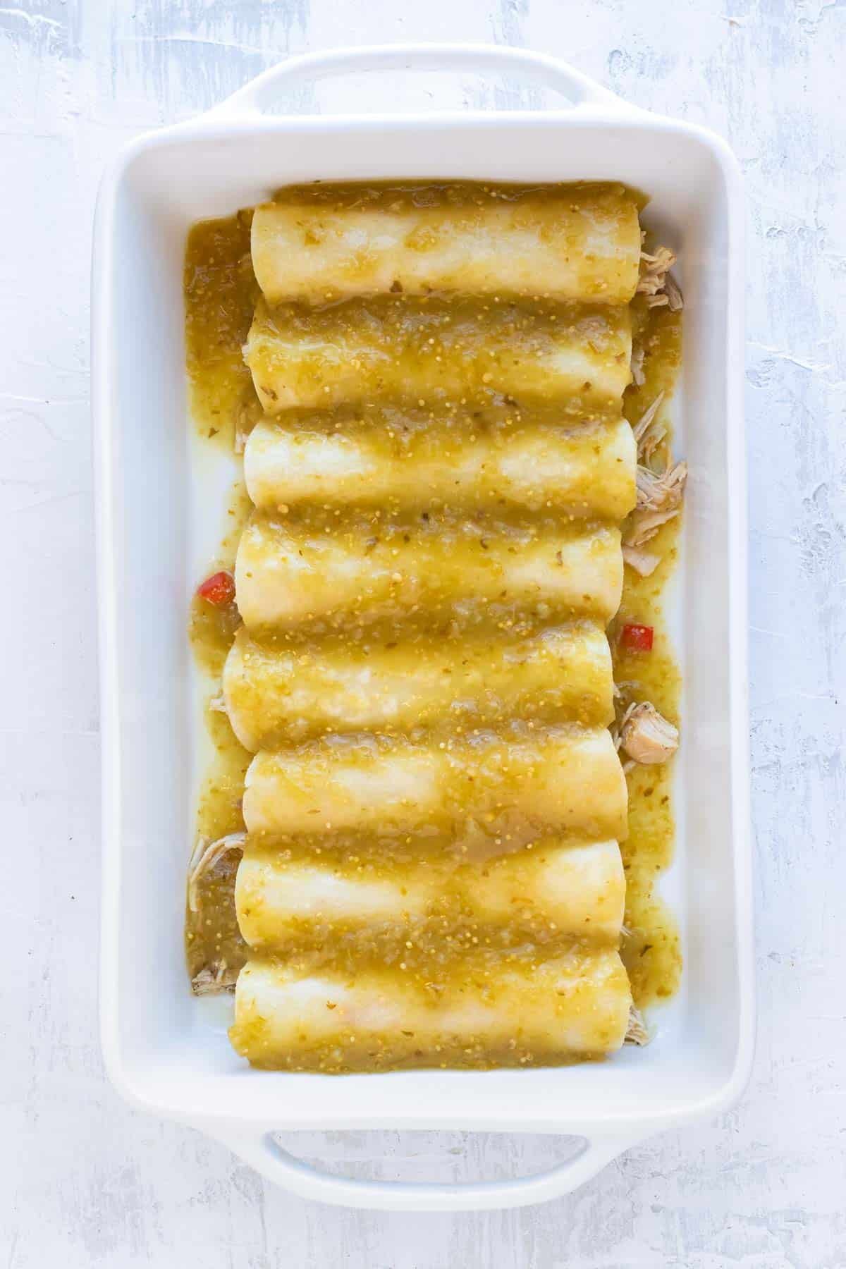 Enchiladas are covered with green sauce.