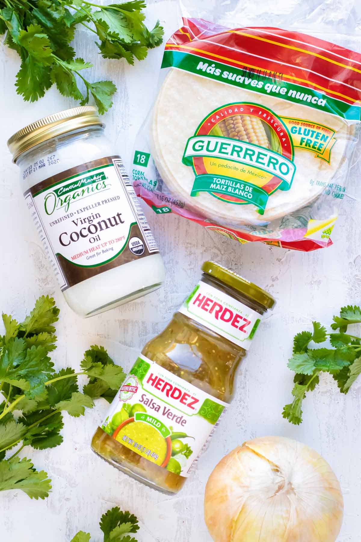 Corn tortillas, coconut oil, and salsa verde as the ingredients for chicken enchiladas verdes.
