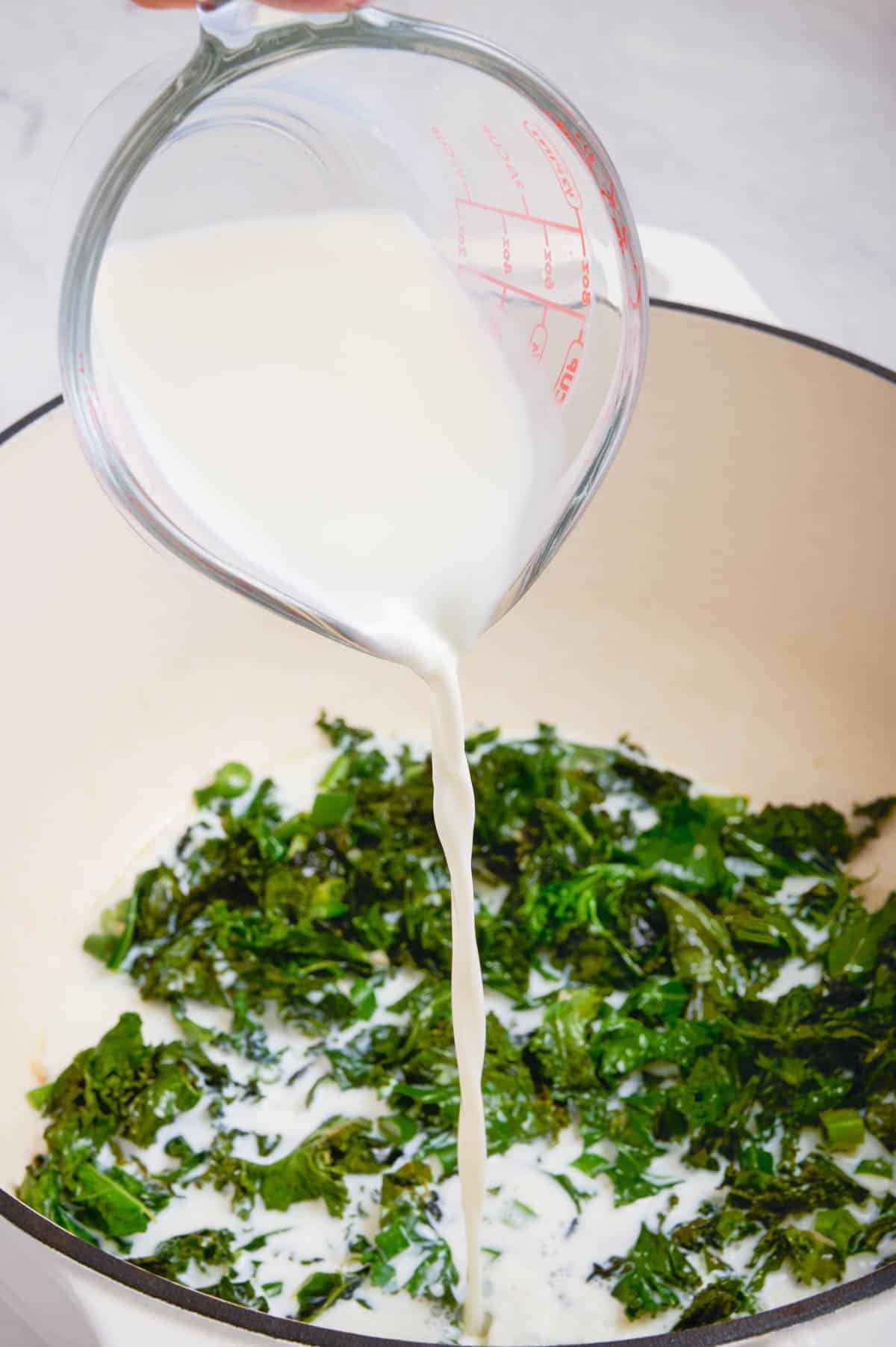 Milk is added to the kale.