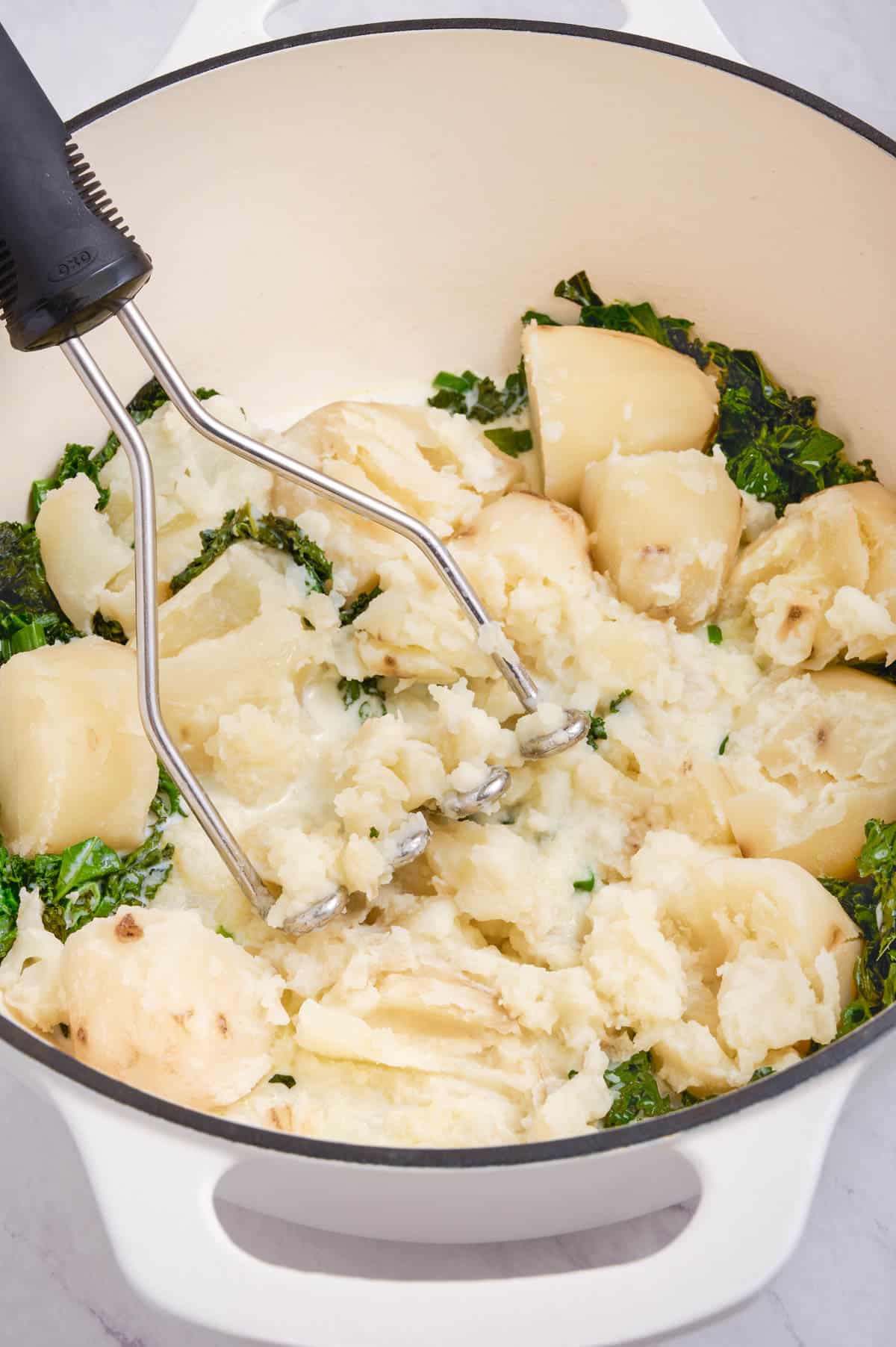 Potatoes are returned to the kale and mashed.