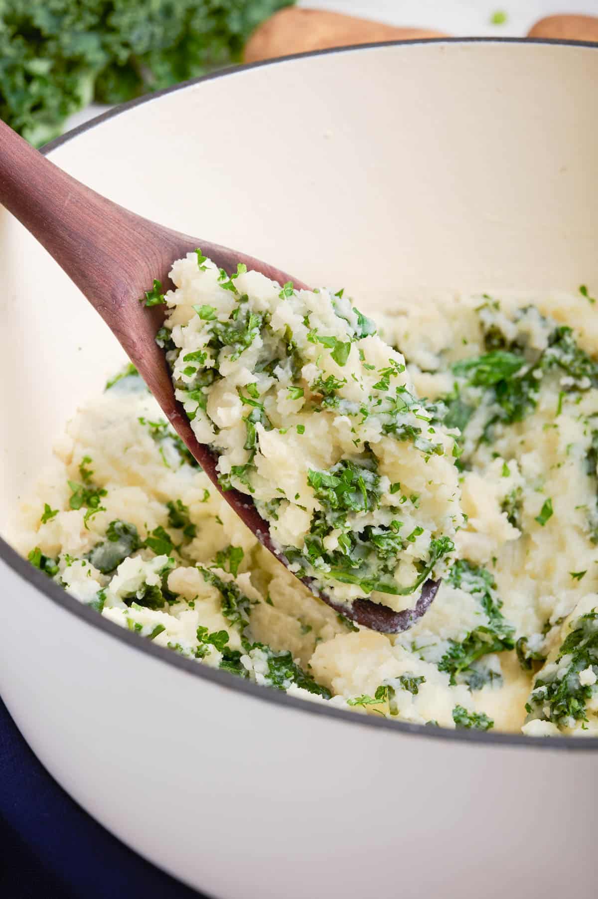 A wooden spoon scoops out a serving of Irish mashed potatoes.