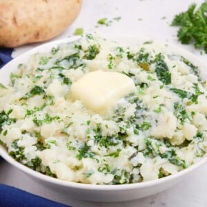 A pat of butter is placed in the middle of a bowl of colcannon.