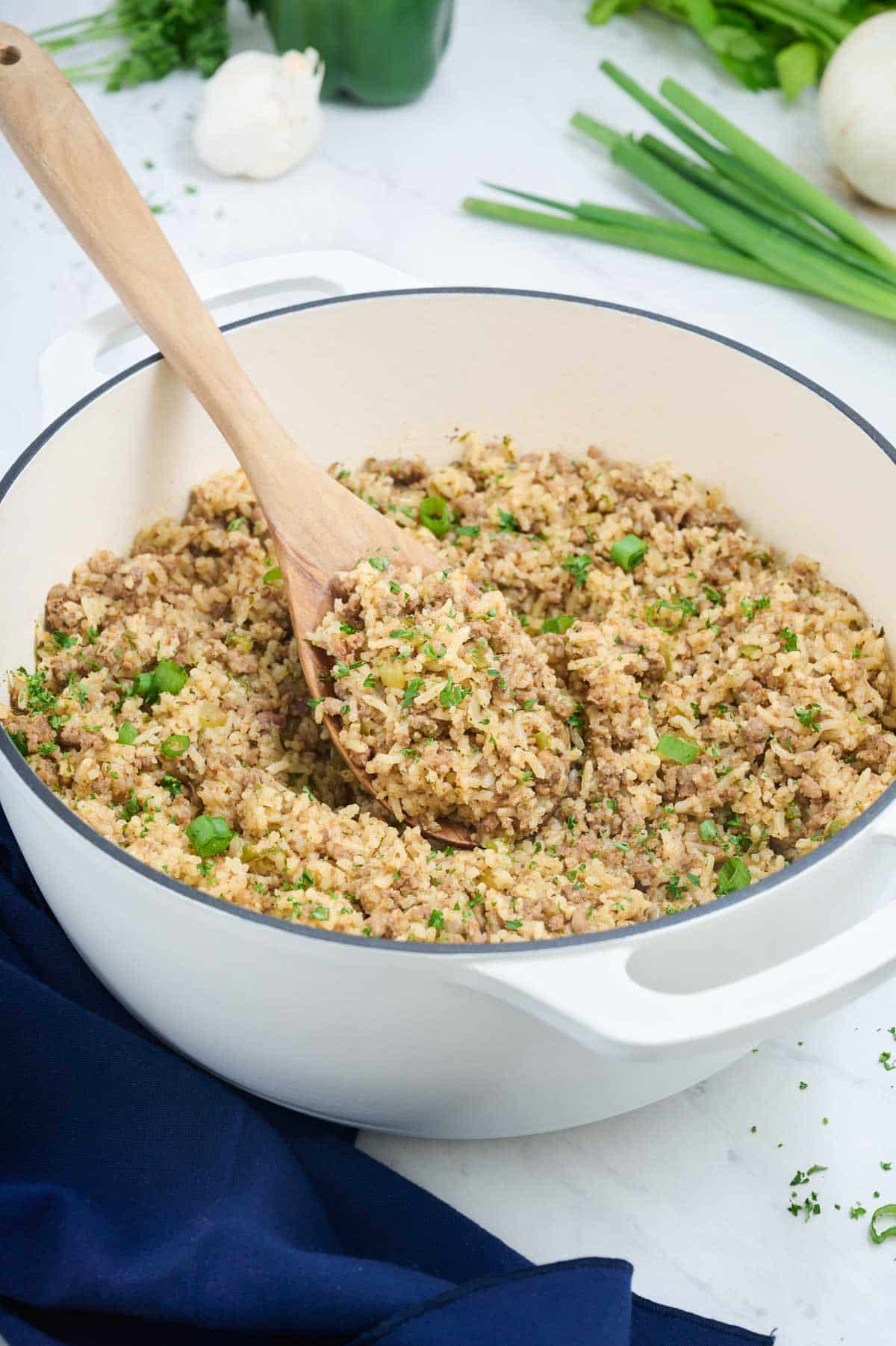 A spoon fluffs up the rice mixture.
