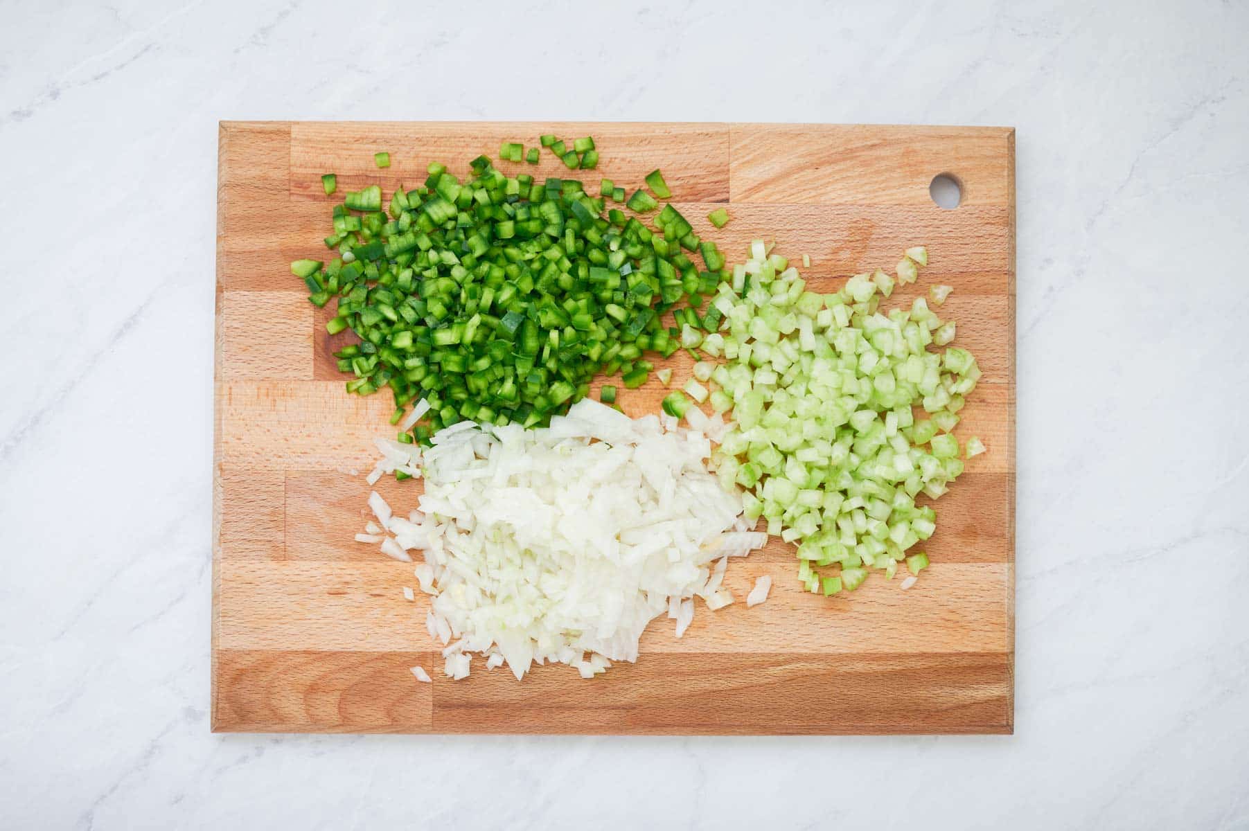 Green bell pepper, celery, and onion are diced.