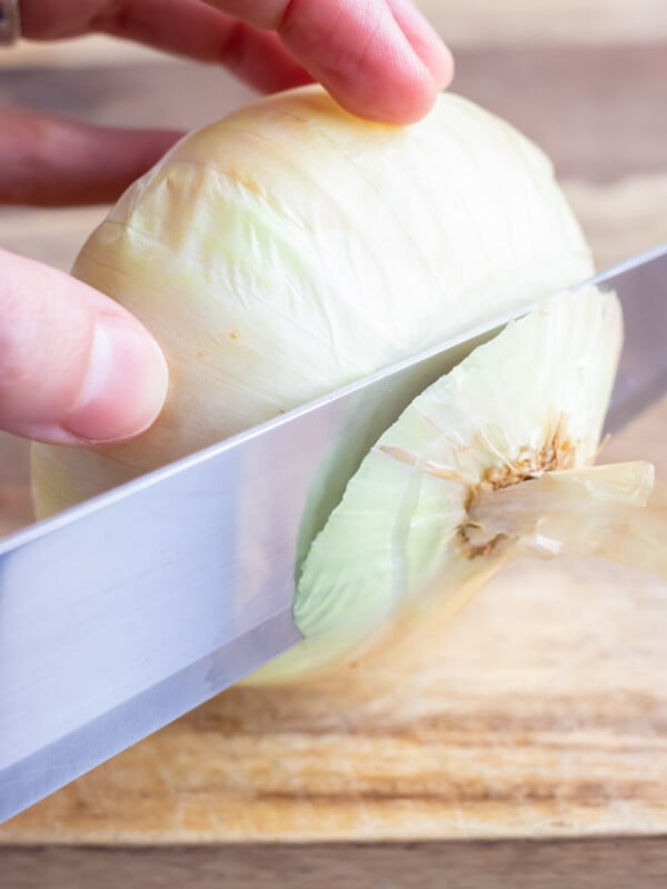 The end of an onion is sliced off.