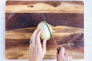 The end of an onion is removed.