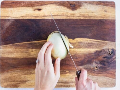 The end of an onion is removed.