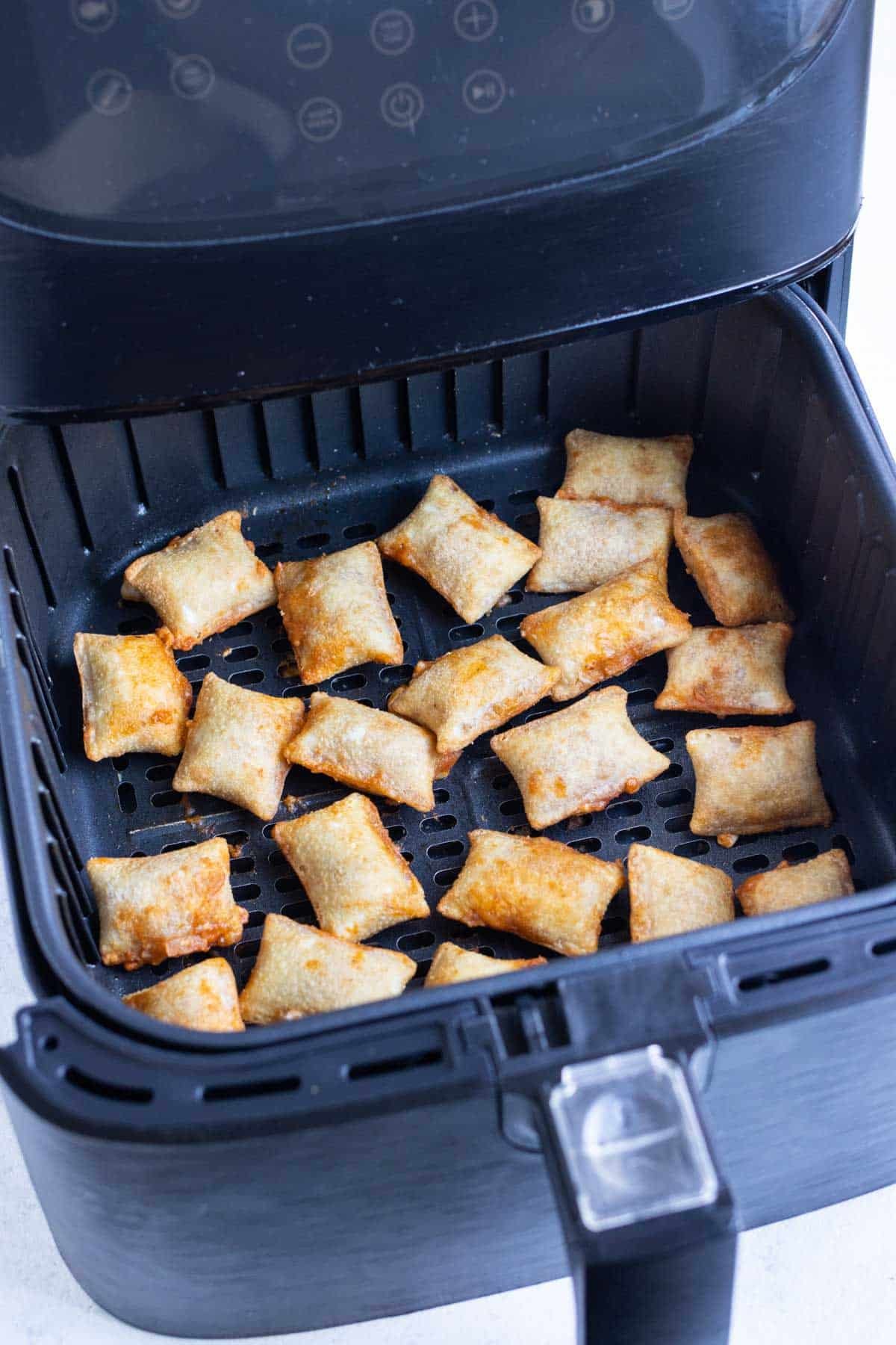 Pizza rolls are cooked to golden in an air fryer.