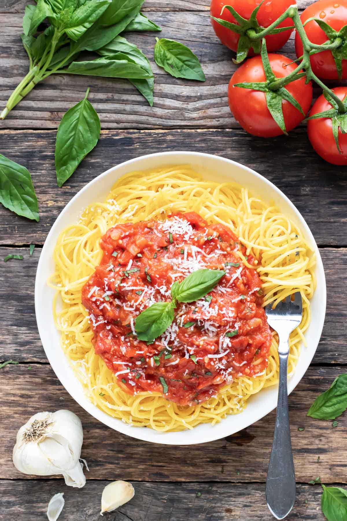 Pomodoro sauce recipe on a bed of gluten-free spaghetti in a white bowl.