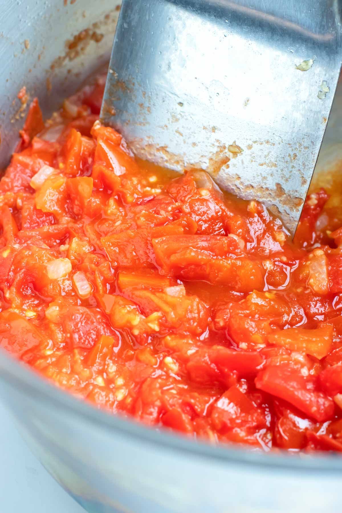 Fresh tomatoes are added to the onions.