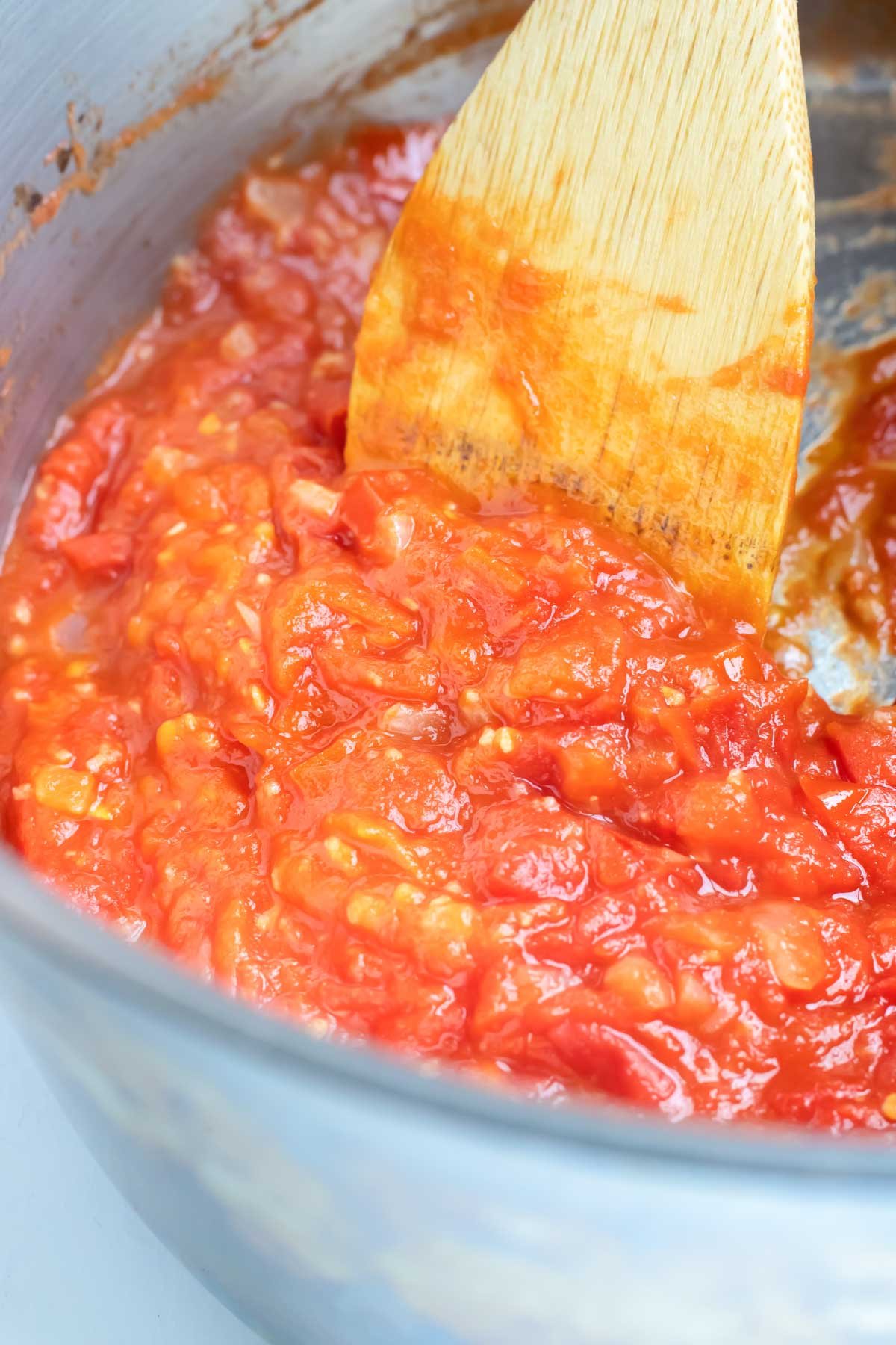The tomatoes are simmered and crushed.