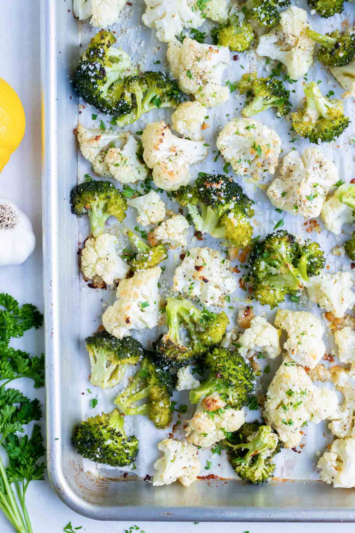Parmesan garlic roasted broccoli cauliflower are baked in the oven for an easy side.