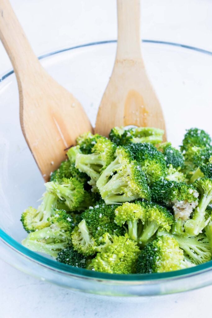 Broccoli florets coated in the same garlic butter sauce before going onto the sheet pan.