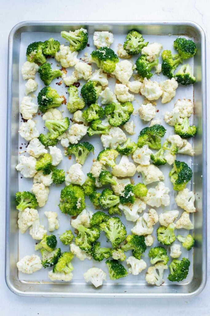 Broccoli added to the sheet pan of cauliflower partway through roasting.