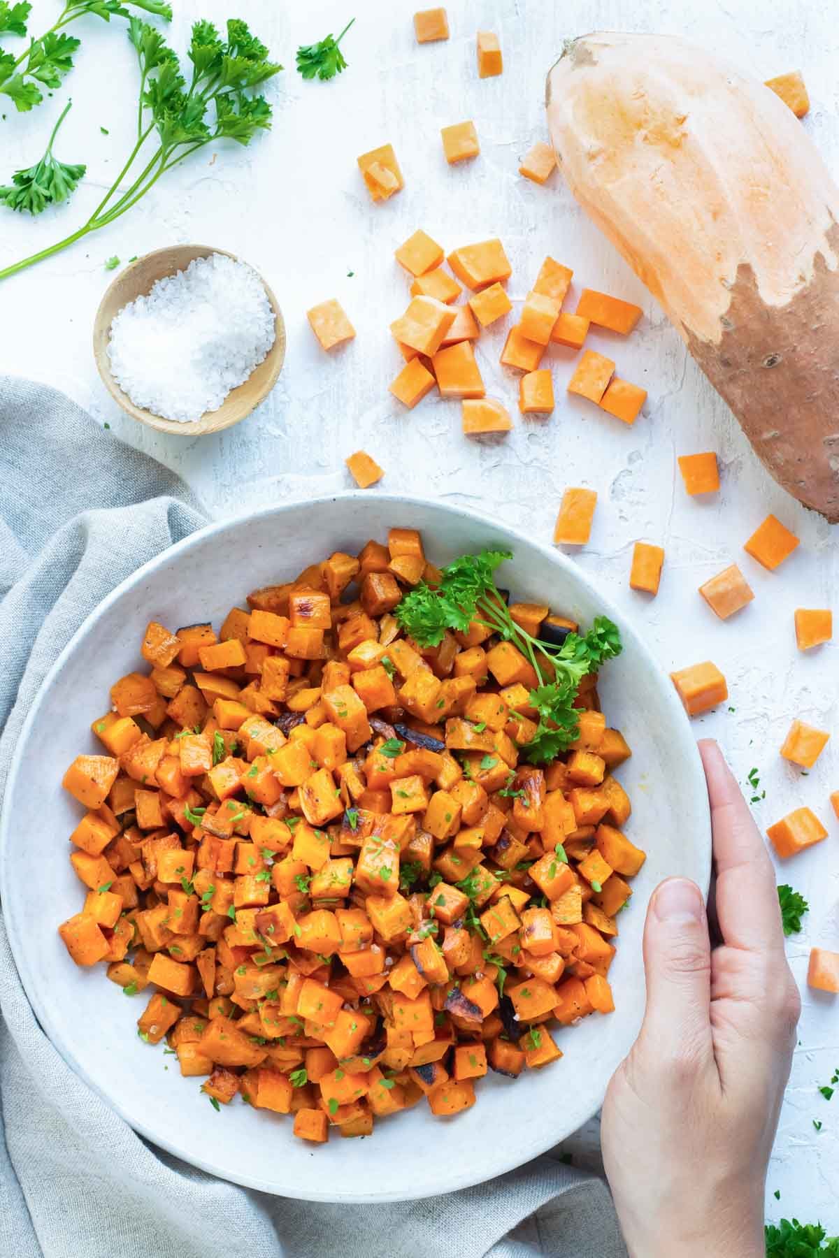 Oven roasted sweet potato cubes in a white bowl.