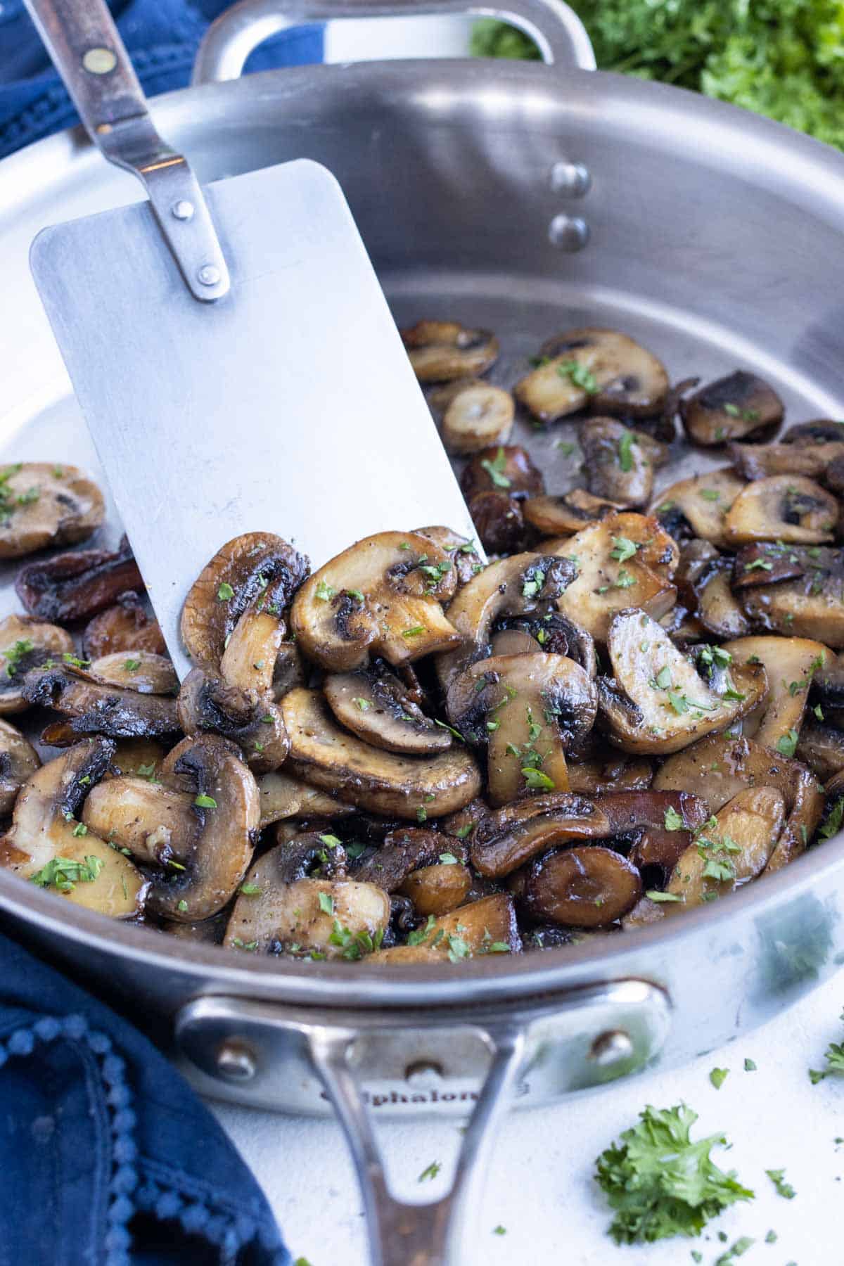A skillet full of mushrooms cooked with butter and garlic.