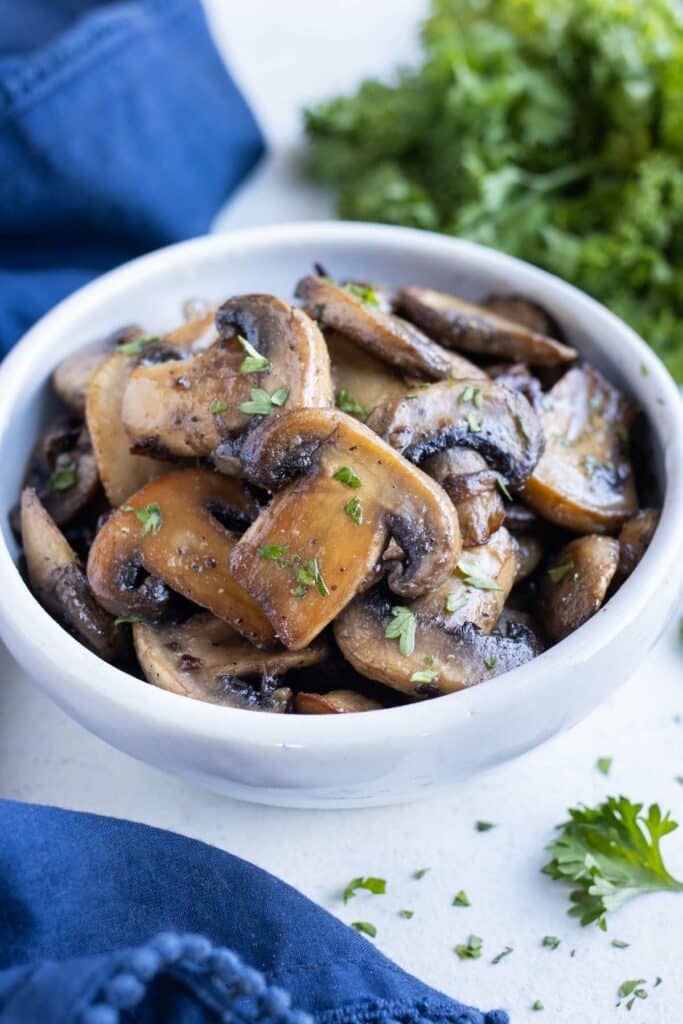 A white bowl with healthy mushrooms.