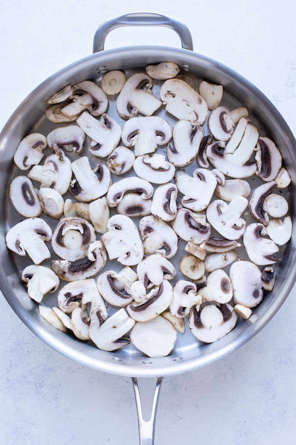 Mushrooms are spread in a single layer in a pan.