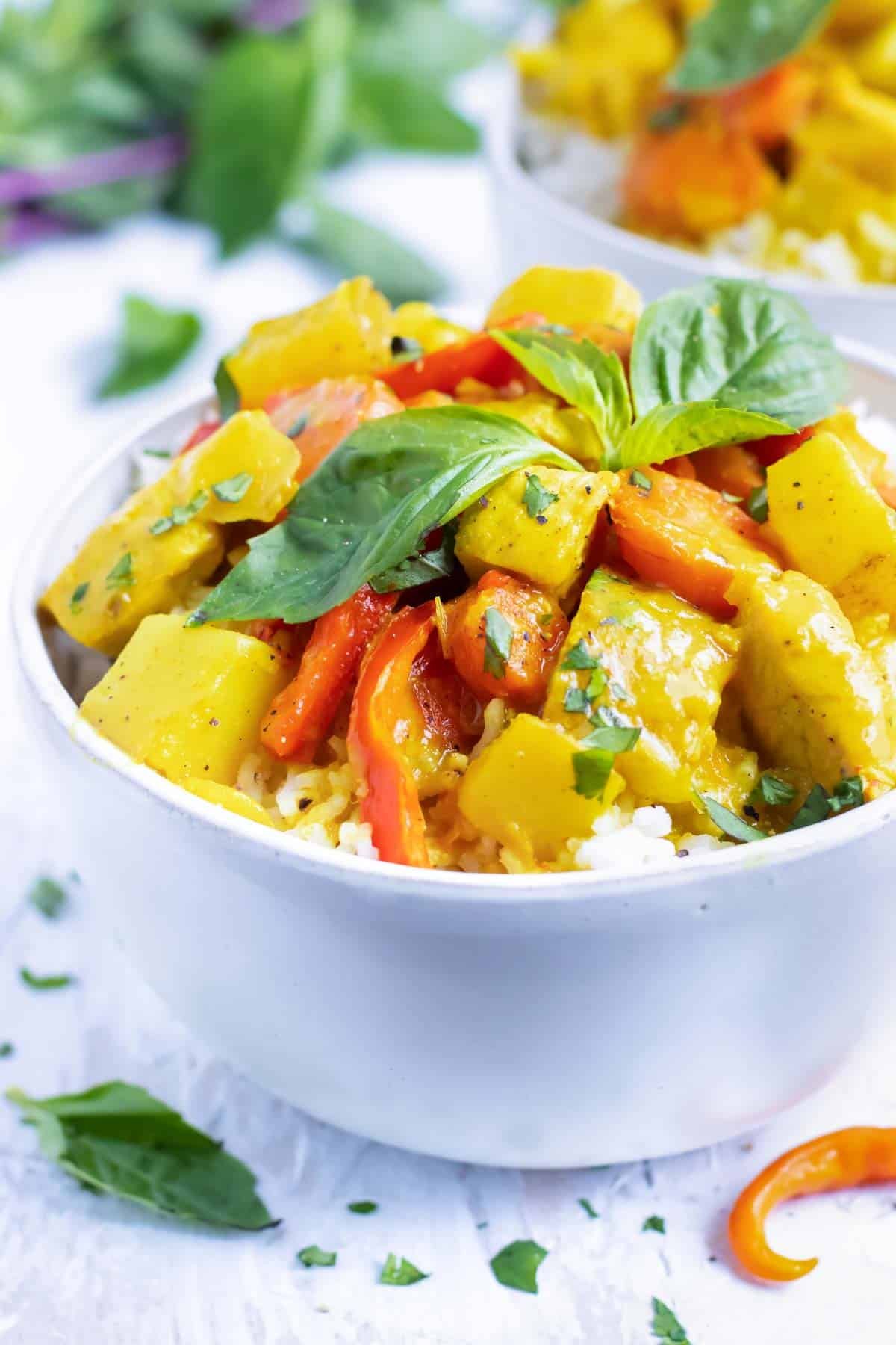 A white bowl full of a yellow curry recipe.