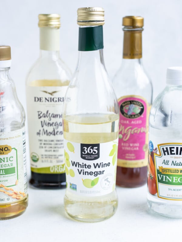 Zoomed-in white wine vinegar surrounded by other assorted vinegars.
