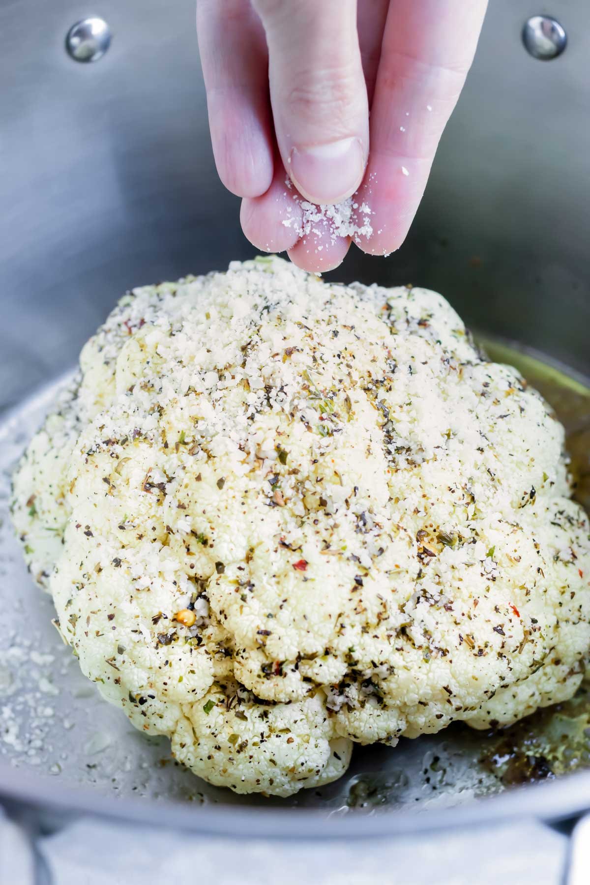 Sprinkle Parmesan cheese on top of the whole cauliflower head and finish roasting.