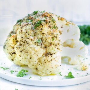 Tender cauliflower is roasted with a garlic and herb butter and topped with Parmesan for a keto side dish.