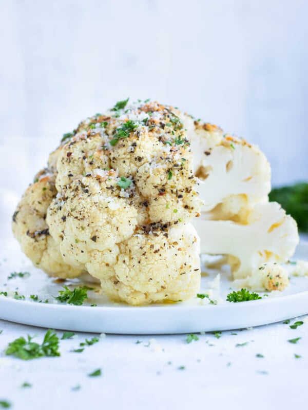 Garlic and herb whole baked cauliflower is a vegetarian side dish for your dinner party.