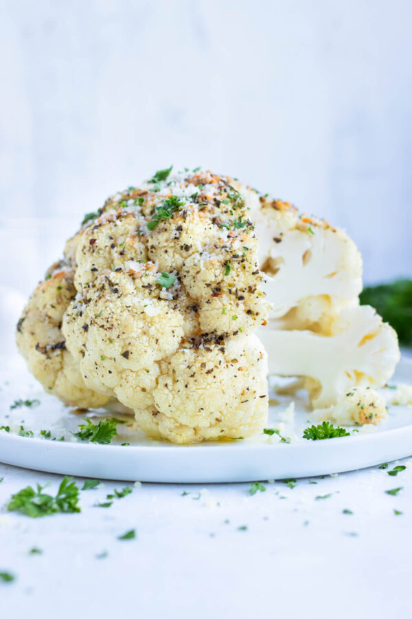 Garlic and herb whole baked cauliflower is a vegetarian side dish for your dinner party.