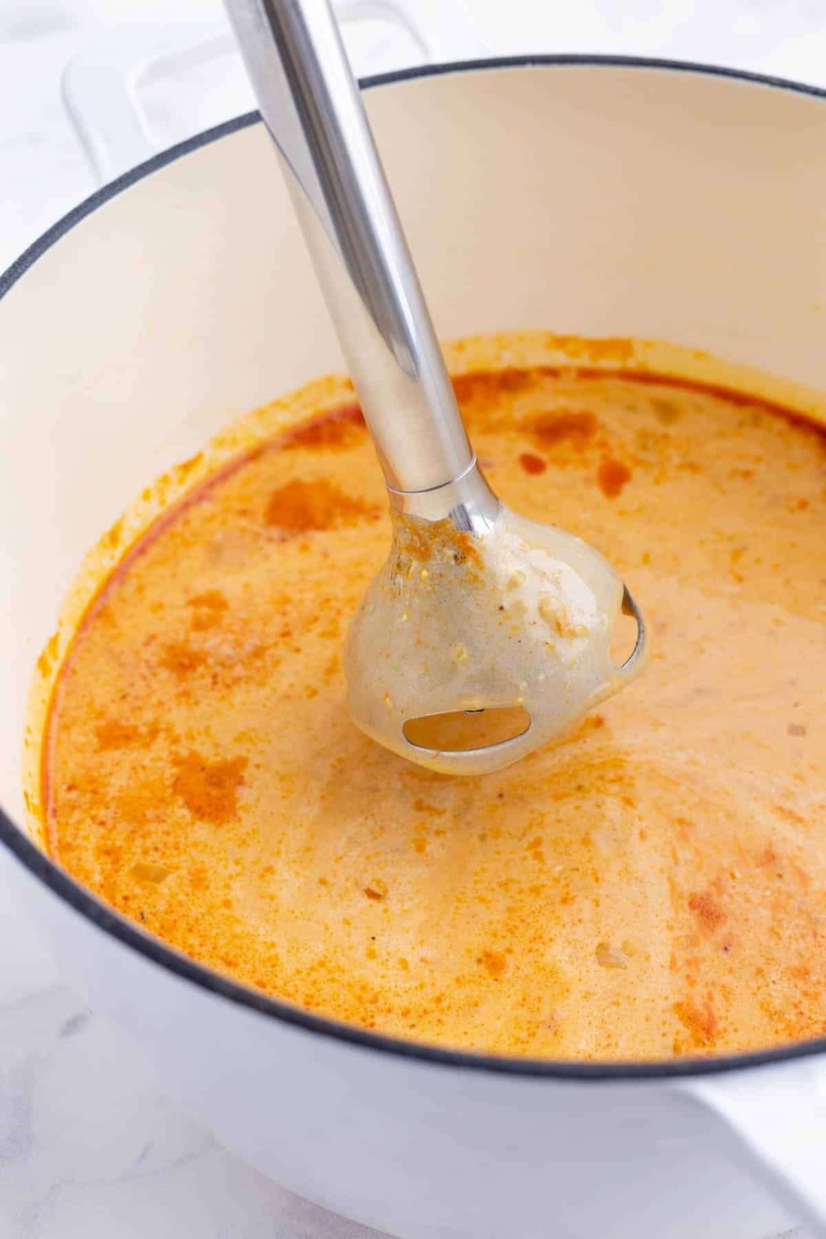 An immersion blender purees the ingredients.