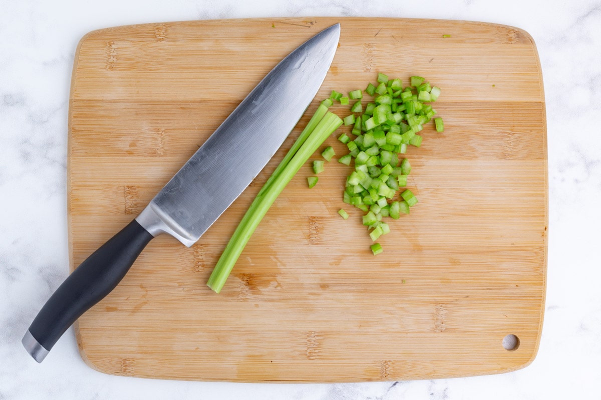 Celery is chopped on a cutting board.