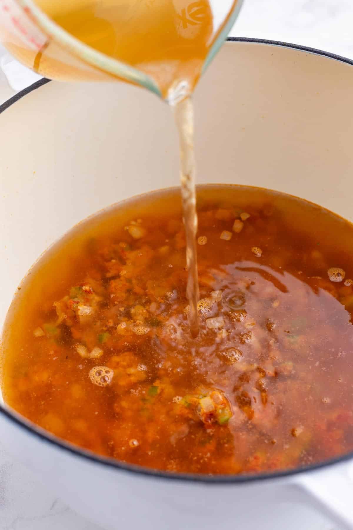 Broth is added to the Dutch oven.