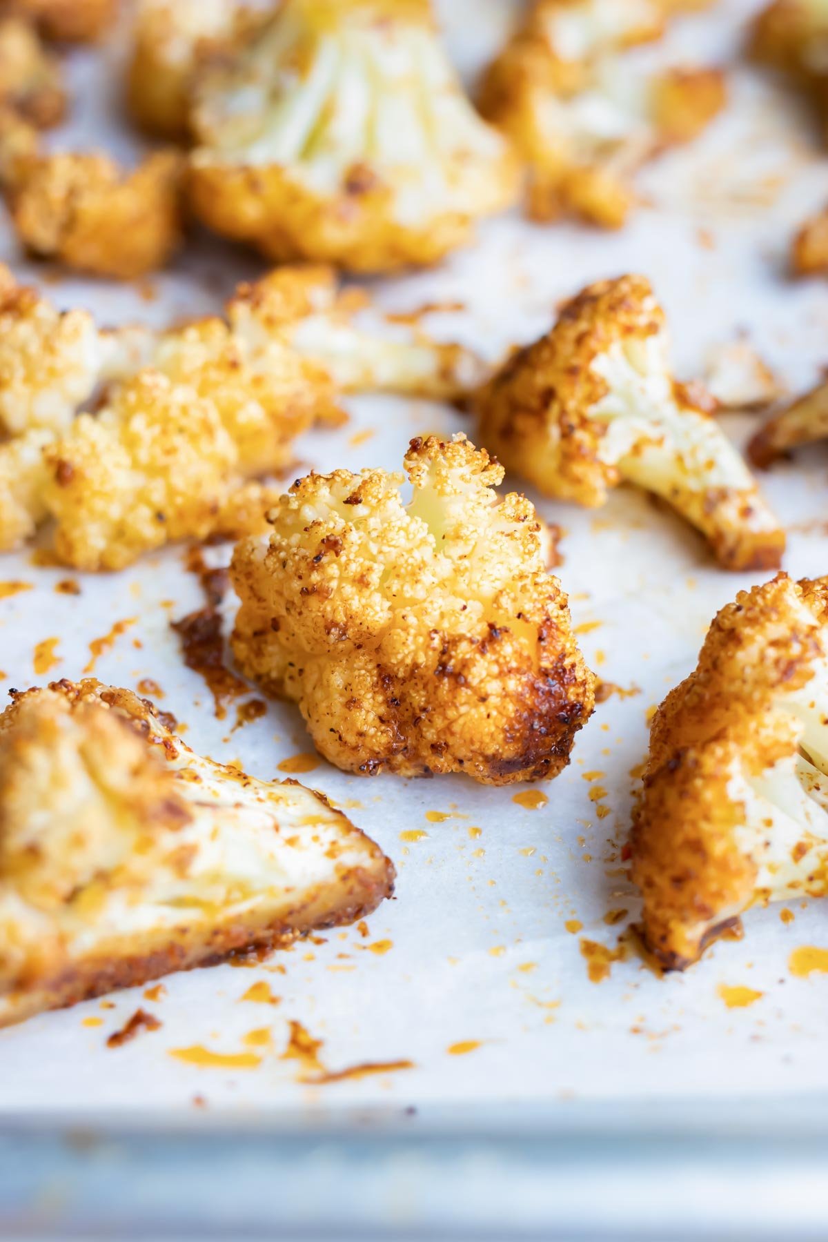 Taco seasoning coated cauliflower on a baking sheet with parchment paper.