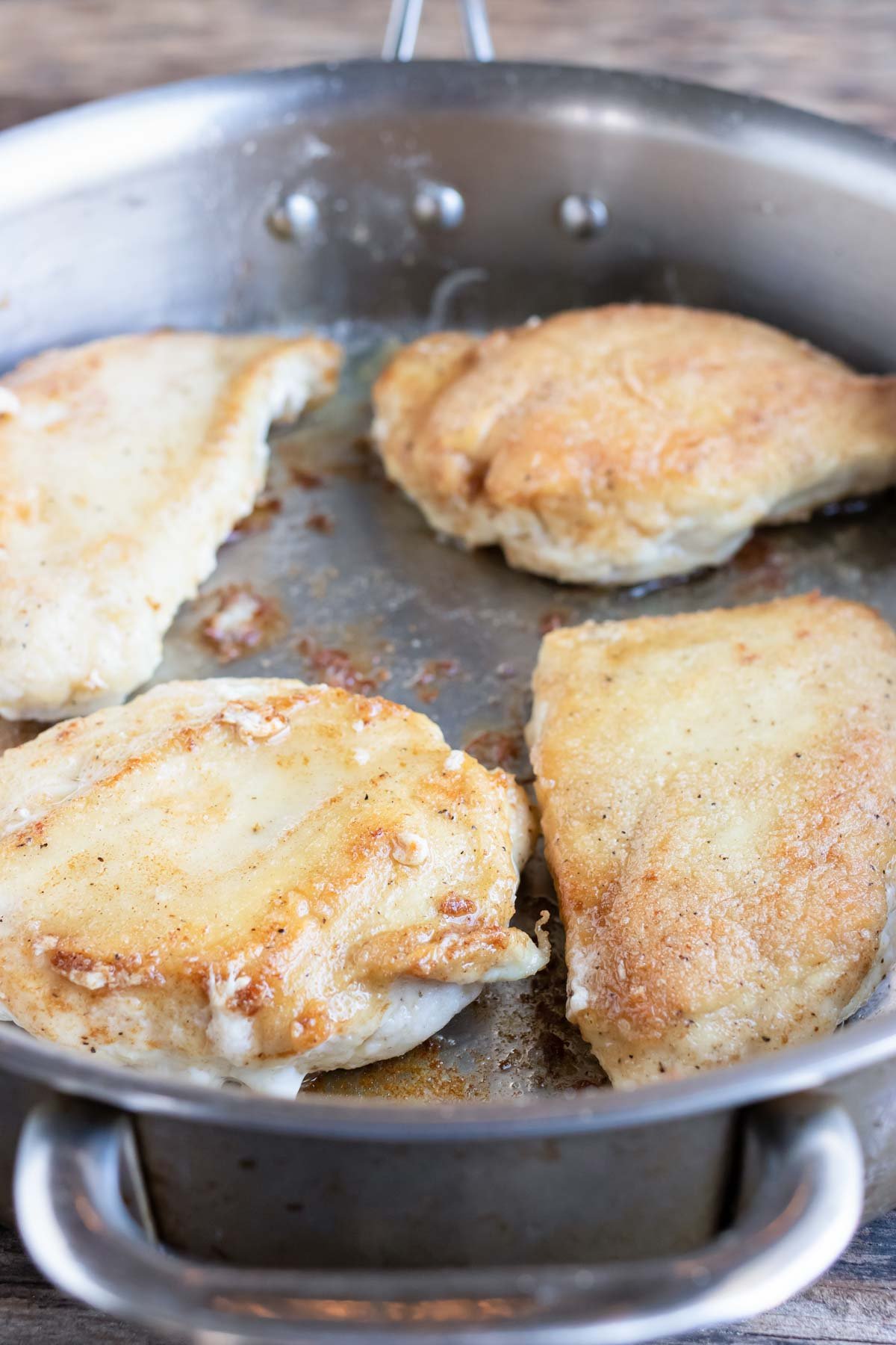 Chicken breasts are flipped during cooking.