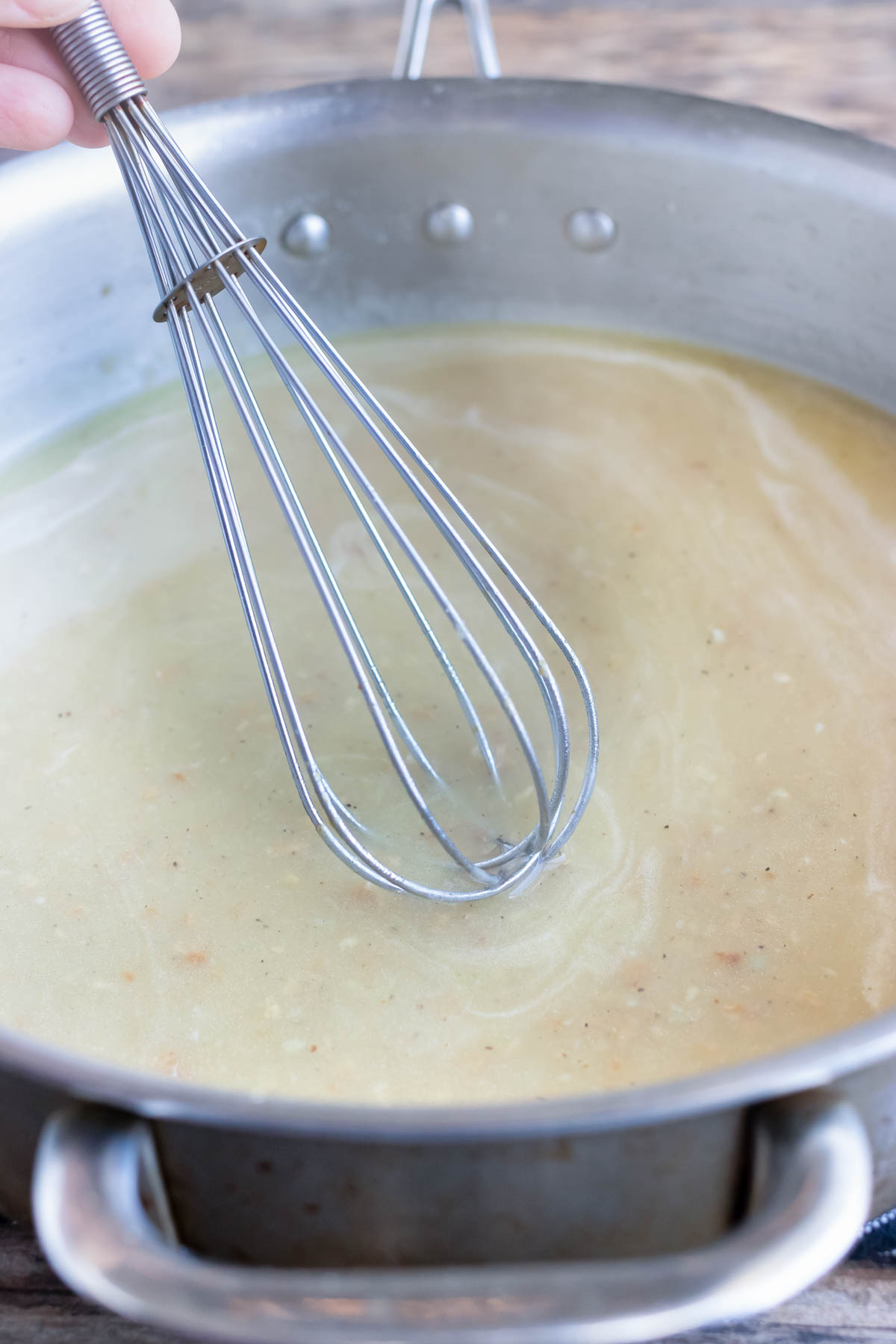 Broth is whisked into the sauce.