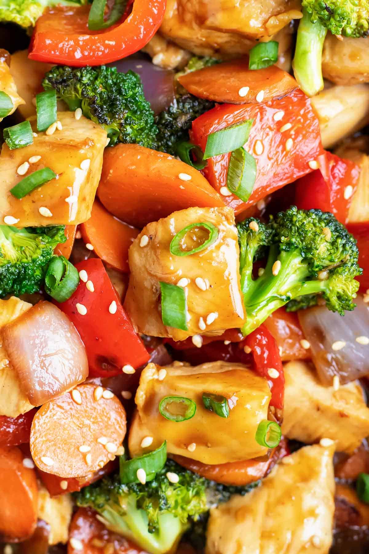 Teriyaki chicken stir-fry with red bell pepper, carrots, broccoli, and red onion.