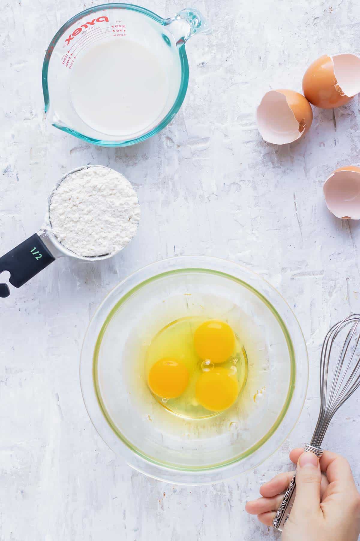 Eggs, milk, and four as the main ingredients in a Dutch baby pancake recipe.