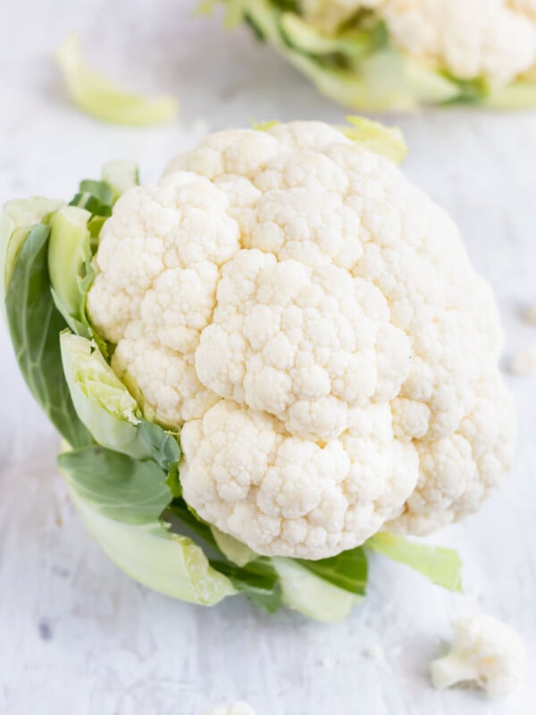 Showing how to select and store cauliflower with bright white curds, green leaves, and adequate firmness.