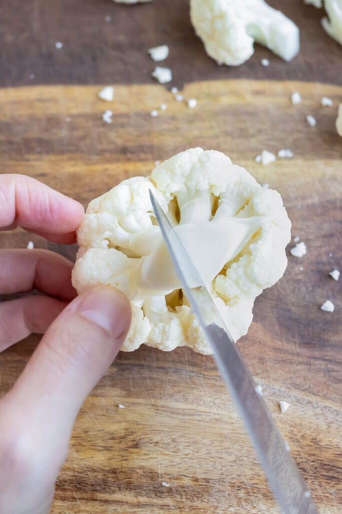 Cutting the end of the cauliflower floret before it is roasted, boiled, or sauteed.