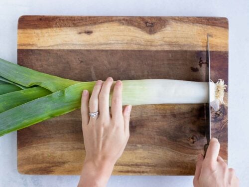 Trimming the root end of a leek.