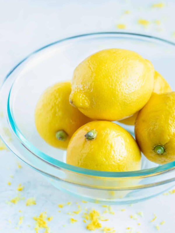 A bowl full of lemons that are waxed and unwaxed.