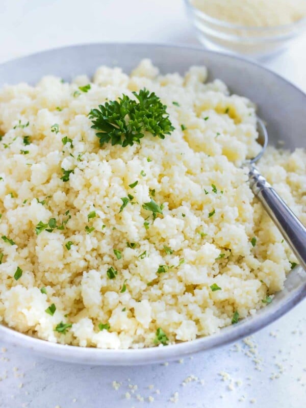 Instant couscous in a grey bowl with parsley sprinkled on top.