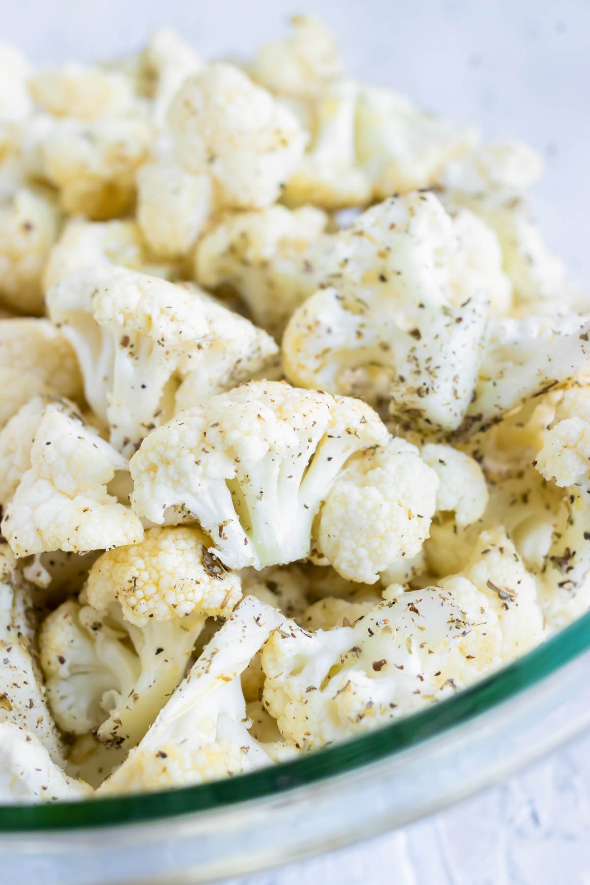 Cauliflower florets in a large bowl with taco seasoning mix.