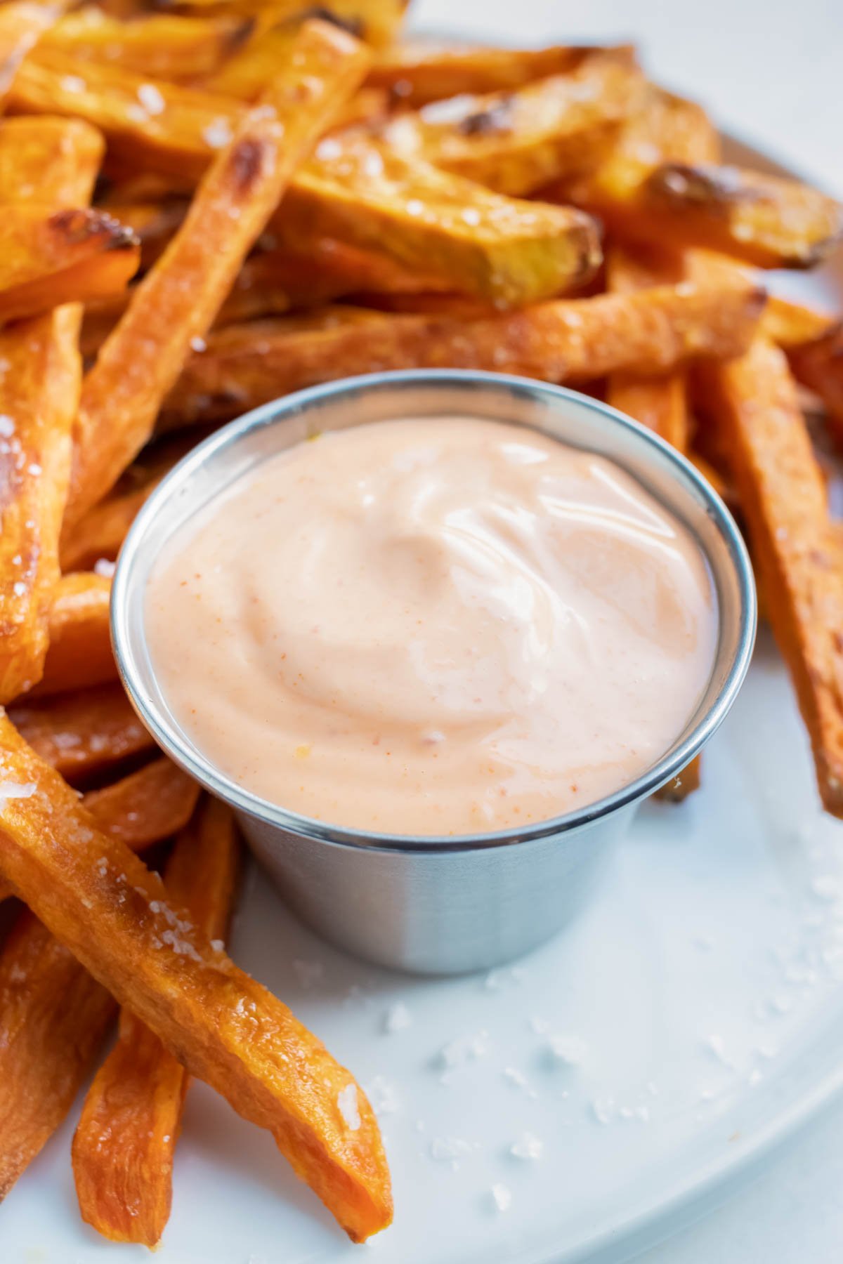 Spicy Sriracha Mayo RECIPE served in a silver cup with sweet potato fries.