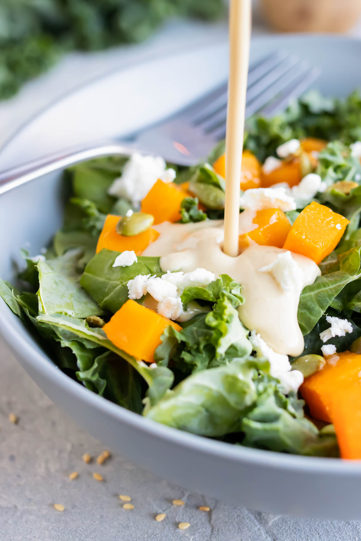 Creamy tahini dressing is poured over a salad