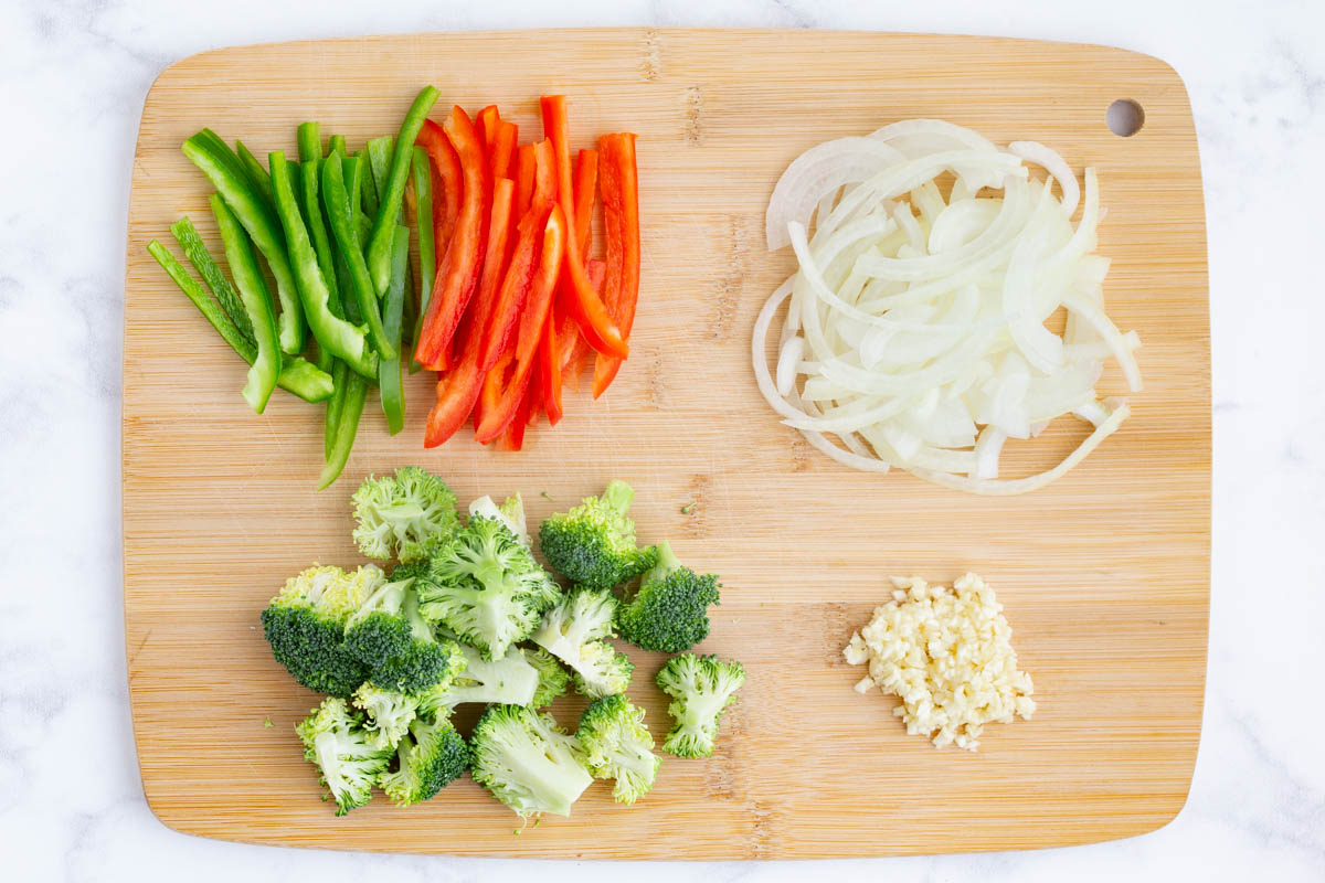 Onions, bell peppers, and broccoli are sliced against the grain.